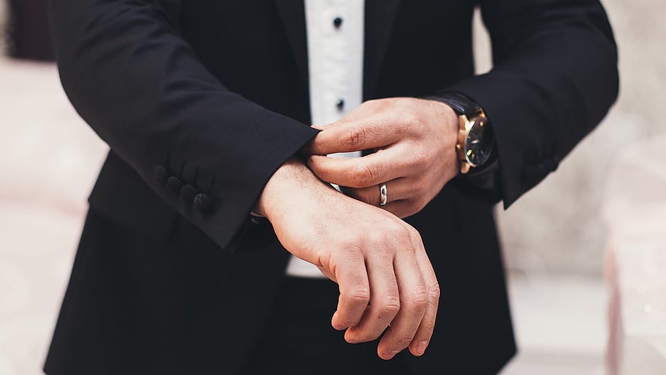 man fixing hem of suit