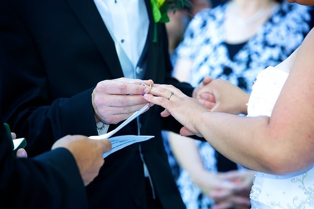 groom and bride exchanging vows and rings in front of a wedding officiant