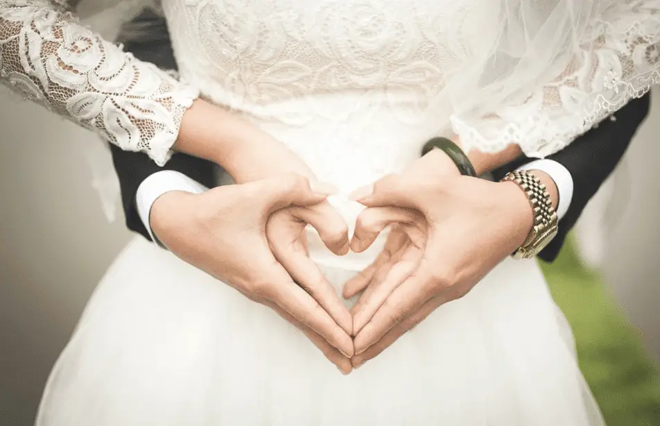 bride and groom on a heart shape hands