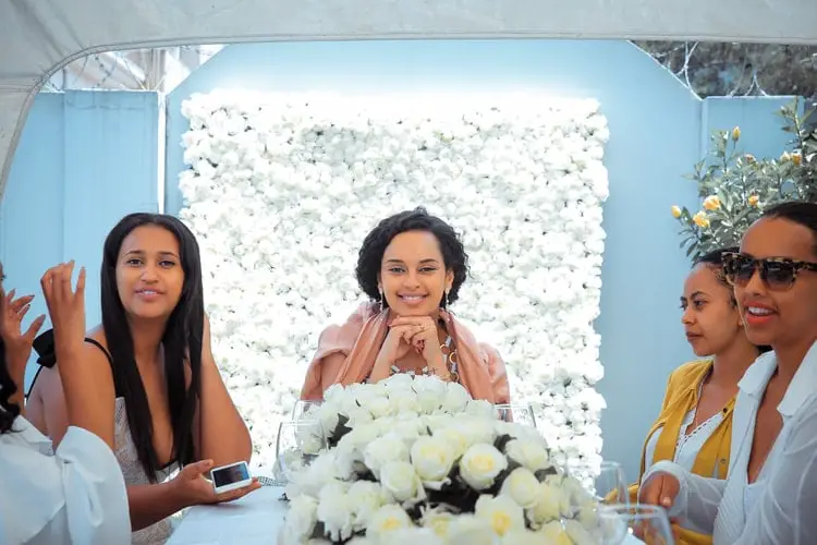 Wedding planner in pink dress sitting between two women