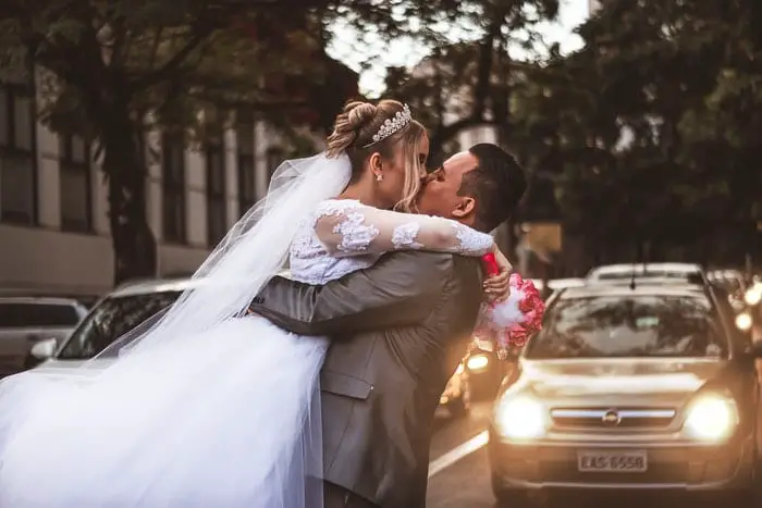 newly wed couple kissing on the street